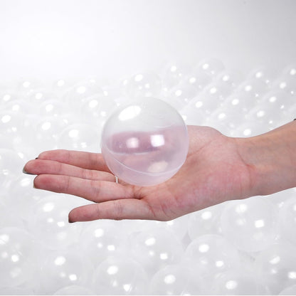 Clear 8 cm transparent ball pit ball displayed on an open hand to demonstrate its size.